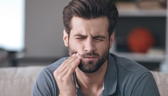 man holding mouth tooth pain
