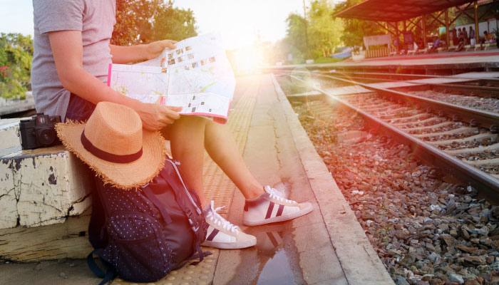 guy traveling, sitting next to railroad tracks