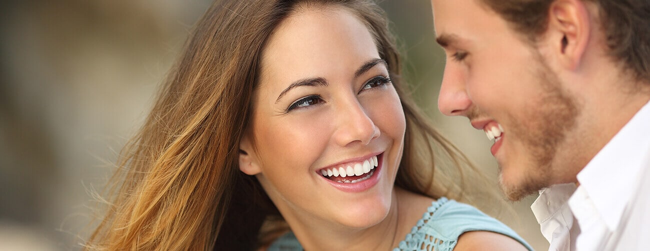 an attractive young woman with a beautiful smile is looking at her friend